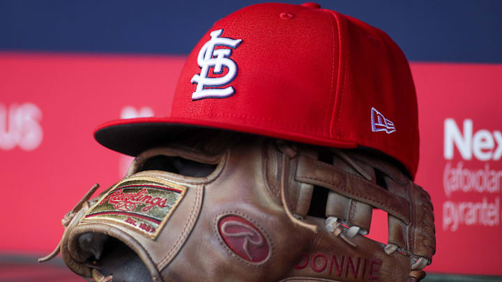 Apr 21, 2025; Atlanta, Georgia, USA; A St. Louis Cardinals hat and glove in the dugout against the Atlanta Braves in the first inning at Truist Park. 