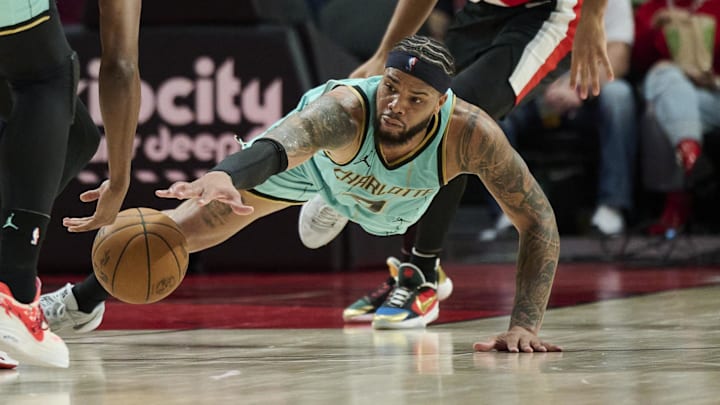 Feb 22, 2025; Portland, Oregon, USA; Charlotte Hornets forward Miles Bridges (0) dives for a lose ball during the second half against Portland Trail Blazers forward Jabari Walker (34) at Moda Center. Mandatory Credit: Troy Wayrynen-Imagn Images