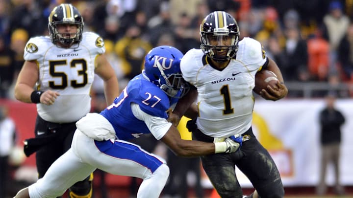 November 26, 2011; Kansas City, MO, USA; Missouri Tigers quarterback James Franklin (1) runs the ball as Kansas Jayhawks defensive back Victor Simmons (27) attempts the tackle in the second quarter at Arrowhead Stadium. Mandatory Credit: Denny Medley-Imagn Images