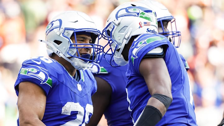 Sep 8, 2024; Seattle, Washington, USA; Seattle Seahawks running back Zach Charbonnet (26) celebrates with quarterback Geno Smith (7) after catching a touchdown pass against the Denver Broncos during the fourth quarter at Lumen Field.