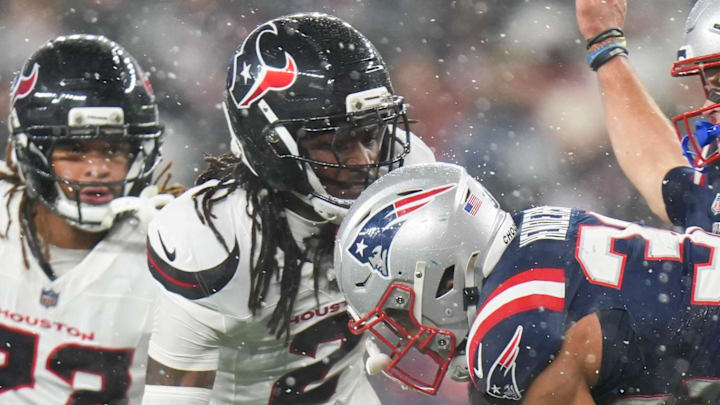 New England Patriots running back TreVeyon Henderson is brought down by Houston Texans cornerback Kamari Lassiter.