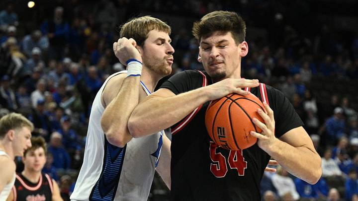 Nov 5, 2025; Omaha, Nebraska, USA;  South Dakota Coyotes center Cameron Fens (54) drives against Creighton Bluejays forward Isaac Traudt (41) during the first half at CHI Health Center Omaha. Mandatory Credit: Steven Branscombe-Imagn Images