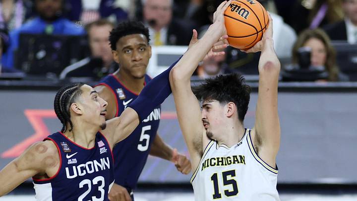 Apr 6, 2026; Indianapolis, IN, USA; Michigan Wolverines center Aday Mara (15) and UConn Huskies forward Jayden Ross (23) fight for the ball in the second half during the national championship of the Final Four of the men's 2026 NCAA Tournament at Lucas Oil Stadium. Mandatory Credit: Trevor Ruszkowski-Imagn Images