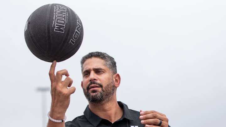 University of Kentucky assistant men's basketball coach Orlando Antigua helped Gage Durrett, 9, spin a basketball on his finger while visiting Pillar's Crestwood Station day program. June 8, 2021

Aj4t3915