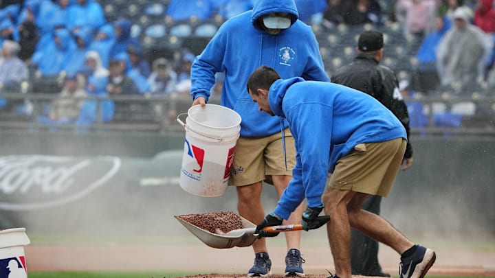 May 26, 2025; Kansas City, Missouri, USA; The Kansas City Royals grounds crew work on the mound during the rain in the fourth inning of the game against the Cincinnati Reds at Kauffman Stadium. Mandatory Credit: Denny Medley-Imagn Images