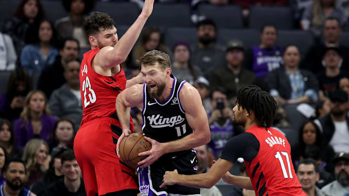Jan 18, 2026; Sacramento, California, USA; Sacramento Kings center Domantas Sabonis (11) drives against Portland Trail Blazers center Donovan Clingan (23) and guard Shaedon Sharpe (17) during the second quarter at Golden 1 Center. Mandatory Credit: Dennis Lee-Imagn Images