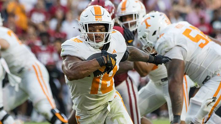 Oct 10, 2026; Fayetteville, Arkansas, USA;  Tennessee Volunteers running back DeSean Bishop (18) gets past Arkansas Razorbacks defensive back Christian Harrison (1) and scores a touchdown during the fourth quarter at Donald W. Reynolds Razorback Stadium.  Mandatory Credit: Brett Rojo-Imagn Images