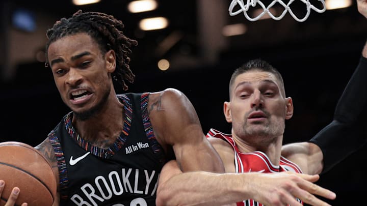 Jan 16, 2026; Brooklyn, New York, USA; Brooklyn Nets center Nic Claxton (33) rebounds against Chicago Bulls center Nikola Vucevic (9) during the second half at Barclays Center. Mandatory Credit: Vincent Carchietta-Imagn Images