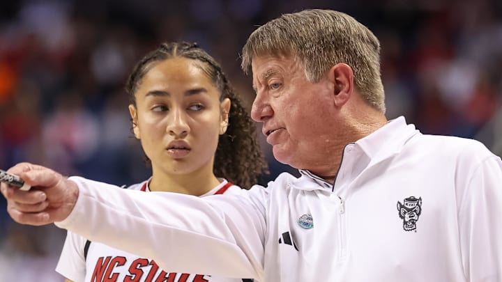Mar 9, 2025; Greensboro, NC, USA;  NC State Wolfpack head coach Wes Moore talks with NC State Wolfpack guard Devyn Quigley (0) during the fourth quarter against Duke Blue Devils at First Horizon Coliseum. Mandatory Credit: Cory Knowlton-Imagn Images