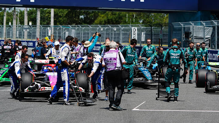 May 4, 2024; Miami Gardens, Florida, USA; Crewmembers push the cars on the grid before the F1 Sprint Race at Miami International Autodrome. Mandatory Credit: John David Mercer-Imagn Images
