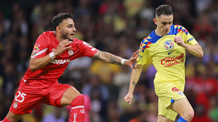 Alexis Vega del Toluca busca robar el esférico al español Álvaro Fidalgo del América