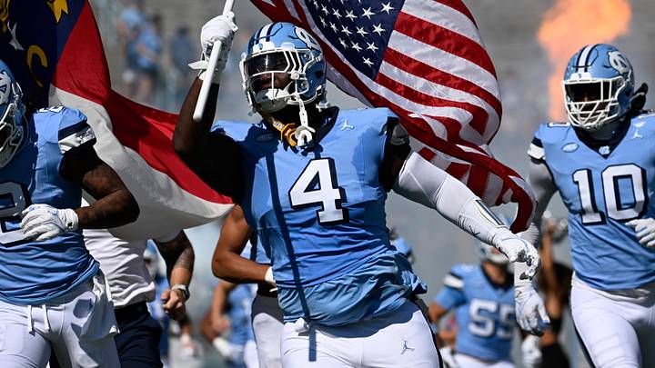 Oct 12, 2024; Chapel Hill, North Carolina, USA; North Carolina Tar Heels defensive lineman Travis Shaw (4) runs on to the field with the american flag before the game at Kenan Memorial Stadium. Mandatory Credit: Bob Donnan-Imagn Images