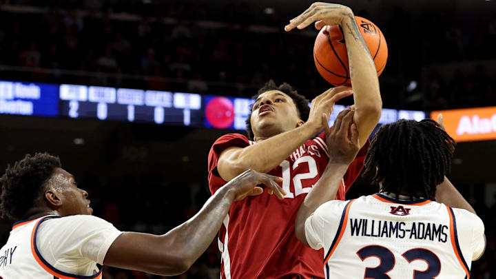 Arkansas Razorbacks forward Malique Ewin (12) loses control of the ball as Auburn Tigers forward Keshawn Murphy (3) and forward Sebastian Williams-Adams (33) defend during the first half at Neville Arena in Auburn, Ala.