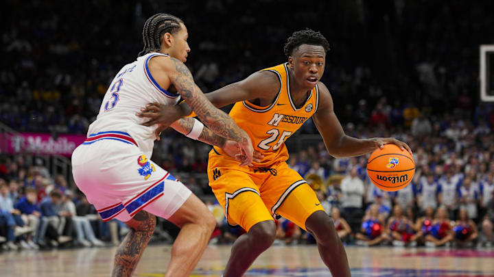 Dec 7, 2025; Kansas City, Missouri, USA; Missouri Tigers forward Mark Mitchell (25) drives against Kansas Jayhawks guard Tre White (3) during the second half at T-Mobile Center. Mandatory Credit: Jay Biggerstaff-Imagn Images