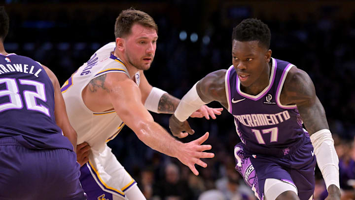Dec 28, 2025; Los Angeles, California, USA;  Sacramento Kings guard Dennis Schroder (17) drives past Los Angeles Lakers guard Luka Doncic (77) in the first half at Crypto.com Arena.