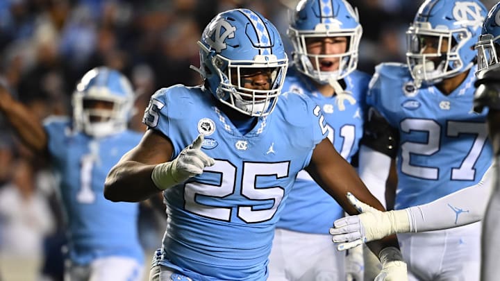 Nov 19, 2022; Chapel Hill, North Carolina, USA; North Carolina Tar Heels defensive lineman Kaimon Rucker (25) reacts with defensive back Giovanni Biggers (27) and defensive lineman Jahvaree Ritzie (5) in the second quarter at Kenan Memorial Stadium. Mandatory Credit: Bob Donnan-Imagn Images Nov 19, 2022; Chapel Hill, North Carolina, USA; North Carolina Tar Heels defensive lineman Kaimon Rucker (25) reacts with defensive back Giovanni Biggers (27) and defensive lineman Jahvaree Ritzie (5) in the second quarter at Kenan Memorial Stadium. Mandatory Credit: Bob Donnan-Imagn Images