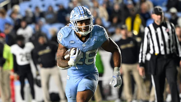 Nov 16, 2024; Chapel Hill, North Carolina, USA; North Carolina Tar Heels running back Omarion Hampton (28) runs as Wake Forest Demon Deacons defensive back Evan Slocum (7) defends in the fourth quarter at Kenan Memorial Stadium. Mandatory Credit: Bob Donnan-Imagn Images Nov 16, 2024; Chapel Hill, North Carolina, USA; North Carolina Tar Heels running back Omarion Hampton (28) runs as Wake Forest Demon Deacons defensive back Evan Slocum (7) defends in the fourth quarter at Kenan Memorial Stadium. Mandatory Credit: Bob Donnan-Imagn Images