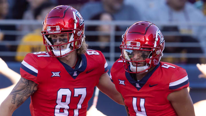 Nov 30, 2024; Tucson, Arizona, USA; Arizona Wildcats wide receiver Tetairoa McMillan (4) celebrates a touchdown with tight end Tyler Powell (87) against the Arizona State Sun Devils during the Territorial Cup at Arizona Stadium. Mandatory Credit: Mark J. Rebilas-Imagn Images Nov 30, 2024; Tucson, Arizona, USA; Arizona Wildcats wide receiver Tetairoa McMillan (4) celebrates a touchdown with tight end Tyler Powell (87) against the Arizona State Sun Devils during the Territorial Cup at Arizona Stadium. Mandatory Credit: Mark J. Rebilas-Imagn Images