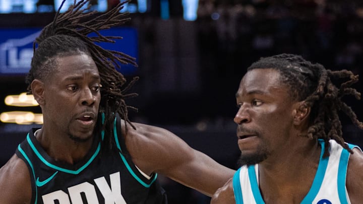 Charlotte Hornets guard Sion James drives to the basket against Portland Trail Blazers guard Jrue Holiday.