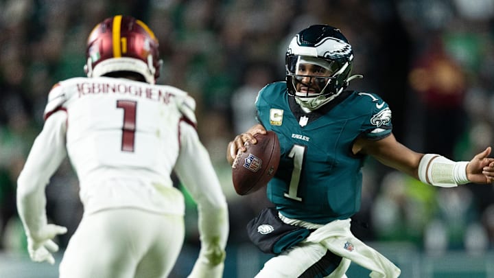 Nov 14, 2024; Philadelphia, Pennsylvania, USA; Philadelphia Eagles quarterback Jalen Hurts (1) runs with the ball in front of Washington Commanders cornerback Noah Igbinoghene (1) during the second quarter at Lincoln Financial Field. Mandatory Credit: Bill Streicher-Imagn Images