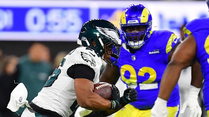 Nov 24, 2024; Inglewood, California, USA; Philadelphia Eagles running back Saquon Barkley (26) runs the ball against Los Angeles Rams defensive tackle Neville Gallimore (92) and defensive tackle Tyler Davis (90) during the first half at SoFi Stadium. Mandatory Credit: Gary A. Vasquez-Imagn Images