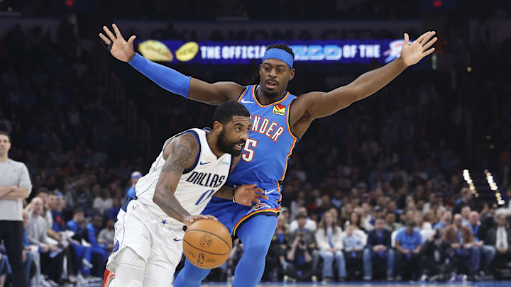 Jan 23, 2025; Oklahoma City, Oklahoma, USA; Dallas Mavericks guard Kyrie Irving (11) drives around Oklahoma City Thunder guard Luguentz Dort (5) during the first quarter at Paycom Center. Mandatory Credit: Alonzo Adams-Imagn Images
