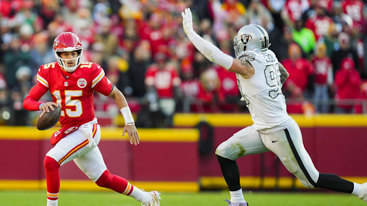 Nov 29, 2024; Kansas City, Missouri, USA; Kansas City Chiefs quarterback Patrick Mahomes (15) scrambles against Las Vegas Raiders defensive end Maxx Crosby (98) during the first half at GEHA Field at Arrowhead Stadium. Mandatory Credit: Jay Biggerstaff-Imagn Images