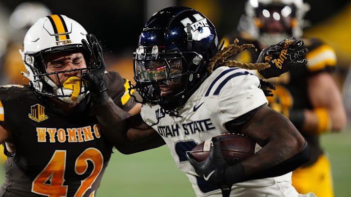 Oct 26, 2024; Laramie, Wyoming, USA; Utah State Aggies running back Rahsul Faison (3) runs against the Wyoming Cowboys during the second quarter at Jonah Field at War Memorial Stadium. Mandatory Credit: Troy Babbitt-Imagn Images