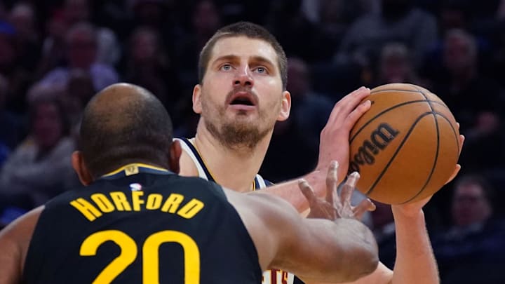 Feb 22, 2026; San Francisco, California, USA;  Denver Nuggets center Nikola Jokic (15) looks to shoot over Golden State Warriors center-forward Al Horford (20) in the third quarter at Chase Center.