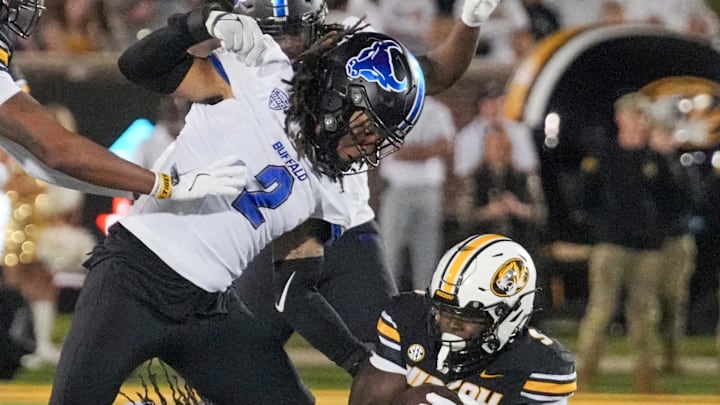 Sep 7, 2024; Columbia, Missouri, USA; Missouri Tigers running back Marcus Carroll (9) runs the ball as Buffalo Bulls linebacker Red Murdock (2) attempts the tackle during the second half at Faurot Field at Memorial Stadium. 