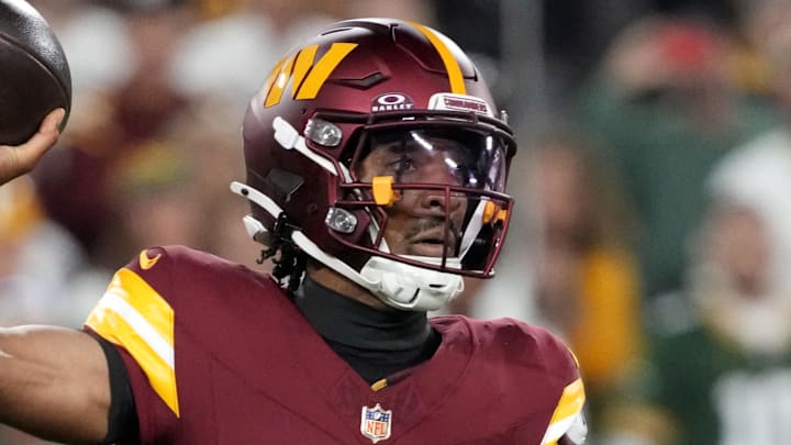 Sep 11, 2025; Green Bay, Wisconsin, USA; Washington Commanders quarterback Jayden Daniels (5) passes against Green Bay Packers defensive end Micah Parsons (1) in the first quarter at Lambeau Field. Mandatory Credit: Jeff Hanisch-Imagn Images