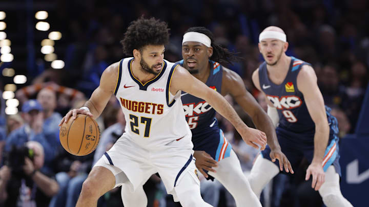 Feb 27, 2026; Oklahoma City, Oklahoma, USA; Denver Nuggets guard Jamal Murray (27) moves the ball around Oklahoma City Thunder guard Luguentz Dort (5) during the third quarter at Paycom Center. Mandatory Credit: Alonzo Adams-Imagn Images