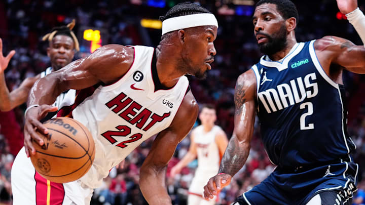 Apr 1, 2023; Miami, Florida, USA; Miami Heat forward Jimmy Butler (22) dribbles the ball past Dallas Mavericks guard Kyrie Irving (2) during the second quarter at Miami-Dade Arena. Mandatory Credit: Rich Storry-Imagn Images