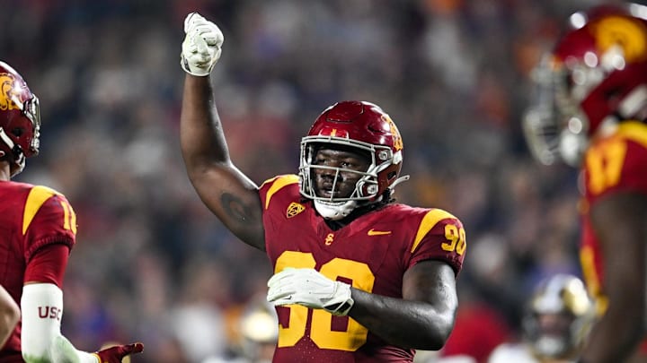 Nov 4, 2023; Los Angeles, California, USA; USC Trojans defensive lineman Bear Alexander (90) celebrates with linebacker Eric Gentry (18) and other teammates against the Washington Huskies during the fourth quarter at United Airlines Field at Los Angeles Memorial Coliseum. Mandatory Credit: Jonathan Hui-Imagn Images