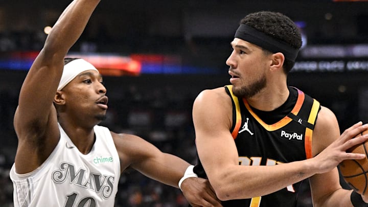 Phoenix Suns guard Devin Booker looks to move the ball past Dallas Mavericks guard Brandon Williams.