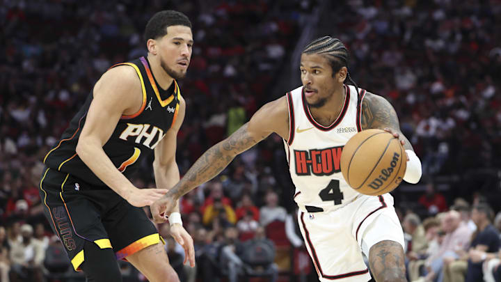 Green dribbles the ball as Suns guard Devin Booker defends.