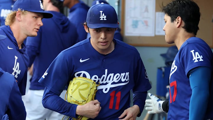 Mar 23, 2026; Los Angeles, California, USA;  Los Angeles Dodgers pitcher Roki Sasaki (11) walks in the dugout after taking out from the game as Los Angeles Dodgers designated hitter Shohei Ohtani (17) pats on the back during the first inning against the Los Angeles Angels at Dodger Stadium. Mandatory Credit: Kiyoshi Mio-Imagn Images