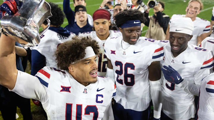 Nov 28, 2025; Tempe, Arizona, USA; Arizona Wildcats defensive back Dalton Johnson (43) celebrates with the Territorial Cup trophy after defeating the Arizona State Sun Devils in the 99th Territorial Cup at Mountain America Stadium. Mandatory Credit: Mark J. Rebilas-Imagn Images Nov 28, 2025; Tempe, Arizona, USA; Arizona Wildcats defensive back Dalton Johnson (43) celebrates with the Territorial Cup trophy after defeating the Arizona State Sun Devils in the 99th Territorial Cup at Mountain America Stadium. Mandatory Credit: Mark J. Rebilas-Imagn Images