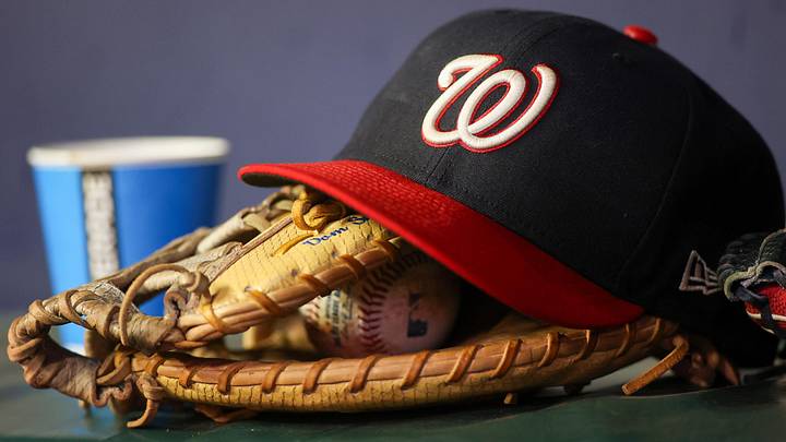 Dark blue Washington Nationals hat on top of a light brown mitt