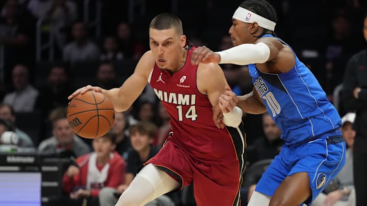 Nov 24, 2025; Miami, Florida, USA; Miami Heat guard Tyler Herro (14) drives to the basket as Dallas Mavericks guard Brandon Williams (10) defends during the first half at Kaseya Center. Mandatory Credit: Jim Rassol-Imagn Images
