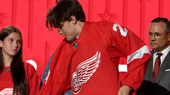 Jun 28, 2023; Nashville, Tennessee, USA; Detroit Red Wings draft pick Axel Sandin Pellikka puts on his sweater after being selected with the seventeenth pick in round one of the 2023 NHL Draft at Bridgestone Arena. Mandatory Credit: Christopher Hanewinckel-Imagn Images
