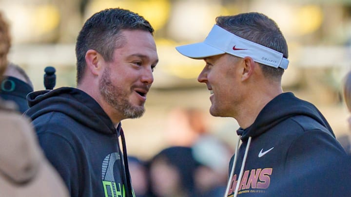 Oregon head coach Dan Lanning, left, and USC head coach Lincoln Riley shake hands before the game as the Oregon Ducks host the USC Trojans on Nov. 22, 2025, at Autzen Stadium in Eugene, Oregon.