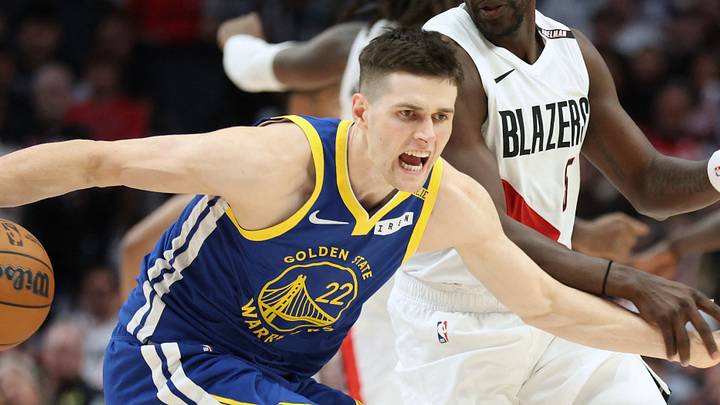 Oct 7, 2026; Portland, Oregon, USA;  Golden State Warriors forward Alex Toohey (22) reacts while being defended by Portland Trail Blazers guard Jrue Holiday (5) during the second half at Moda Center.  Mandatory Credit: Jaime Valdez-Imagn Images