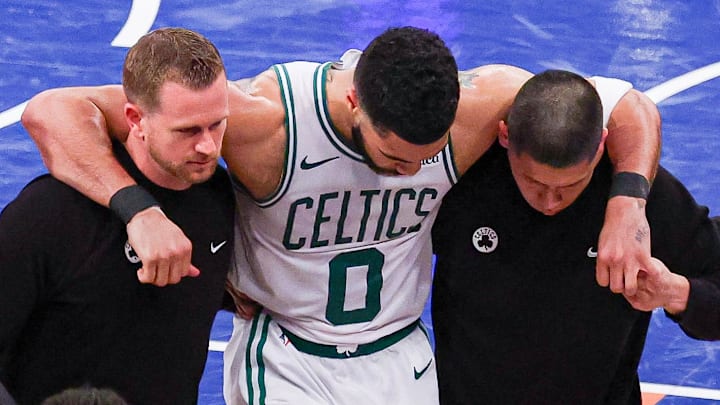 May 12, 2025; New York, New York, USA; Boston Celtics forward Jayson Tatum (0) is helped off the court by after an injury in the second half during game four of the second round for the 2025 NBA Playoffs against the New York Knicks at Madison Square Garden. Tatum would leave the game with an injury after this play. Mandatory Credit: Vincent Carchietta-Imagn Images