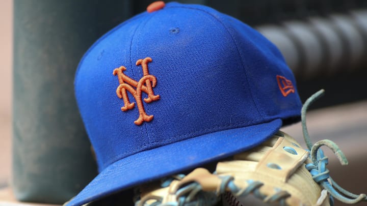 Jul 13, 2022; Atlanta, Georgia, USA; A detailed view of a New York Mets hat and glove in the dugout against the Atlanta Braves in the eighth inning at Truist Park. 