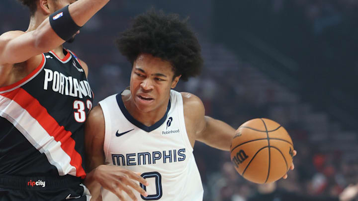Nov 10, 2024; Portland, Oregon, USA; Memphis Grizzlies forward Jaylen Wells (0) drives the lane against Portland Trail Blazers forward Toumani Camara (33) in the first half at Moda Center. Mandatory Credit: Jaime Valdez-Imagn Images
