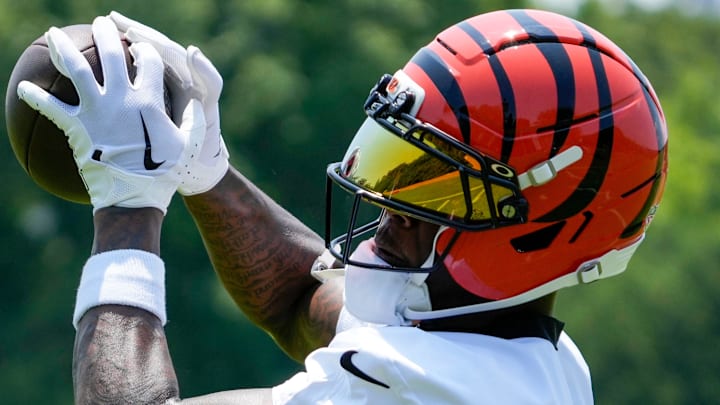 Cincinnati Bengals wide receiver Tee Higgins (5) catches a pass during a session of organized team activities on the Bengals practice field at Paycor Stadium in downtown Cincinnati on Tuesday, June 3, 2025.