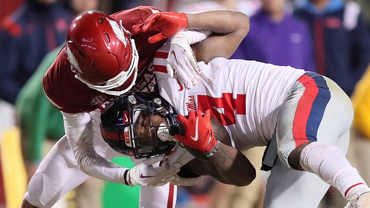 Ole Miss Rebels running back Quinshon Judkins (4) is tackled by Arkansas Razorbacks defensive back Hudson Clark (17) during the fourth quarter at Razorback Stadium. Arkansas won 42-27.