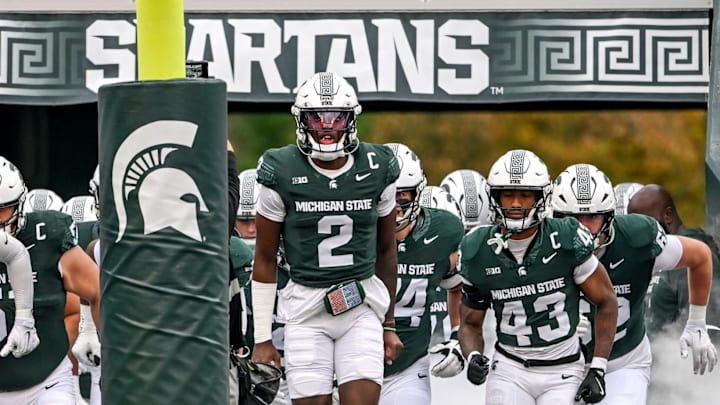 Michigan State's Aidan Chiles, center, and the Spartans take the field before the game against UCLA on Saturday, Oct. 11, 2025, at Spartan Stadium in East Lansing.