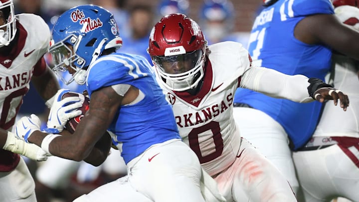 Ole Miss Rebels running back Kewan Lacy (5) runs the ball as Arkansas Razorbacks defensive lineman Justus Boone (0) attempts to make the tackle during the third quarter at Vaught-Hemingway Stadium in Oxford, Miss.